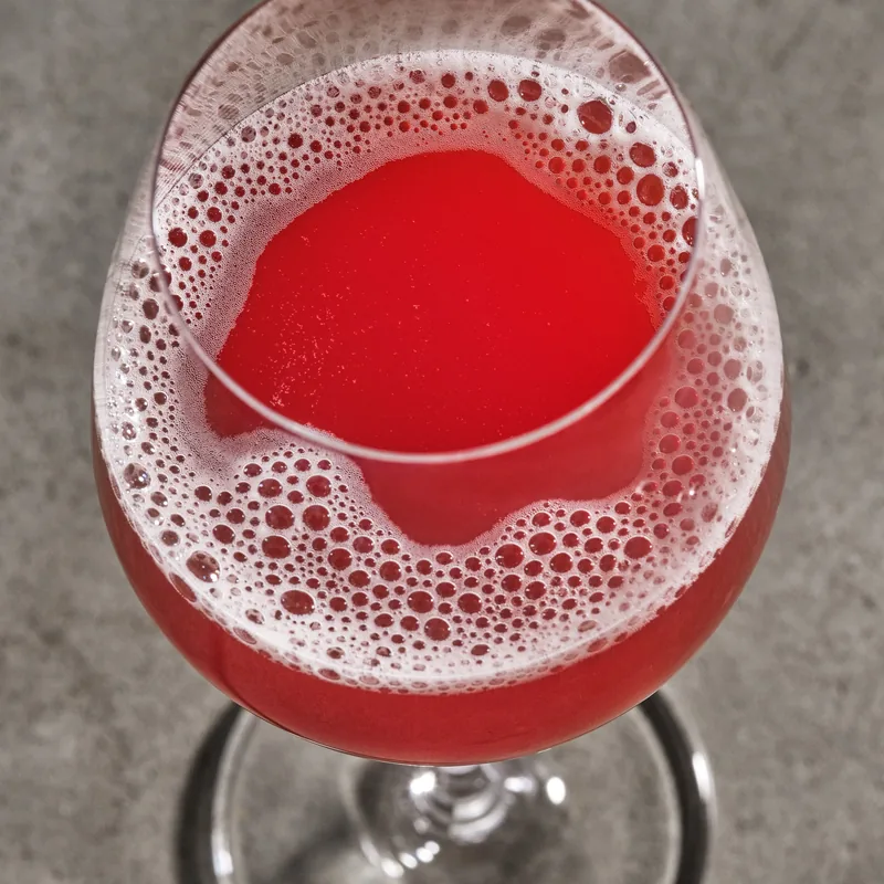 Fade to Black in a wine glass, bright red under a pink foam